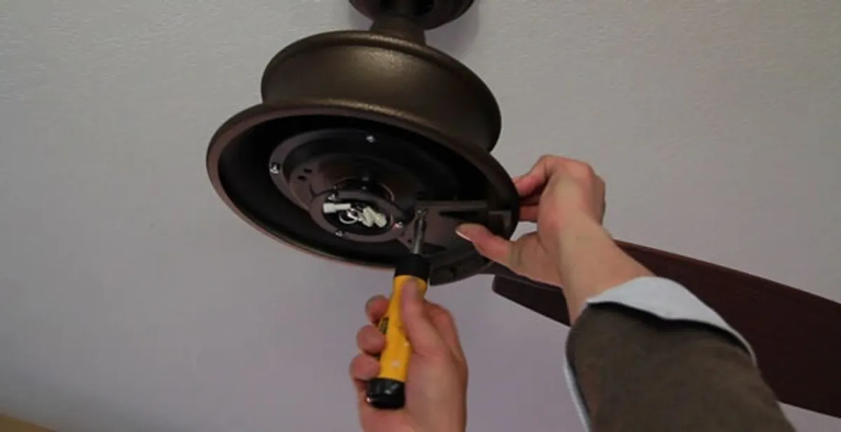 Electrician installing ceiling fan mounting bracket and fixture in Tampa, FL