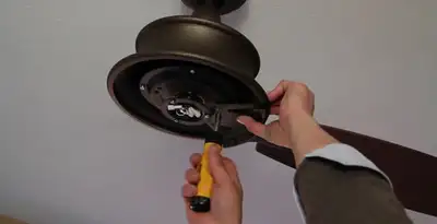Electrician installing ceiling fan mounting bracket and fixture in Tampa, FL