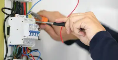 Electrician installing and adjusting circuit breakers in an electrical panel in Tampa, FL
