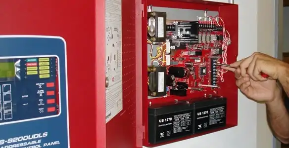 fire alarm installation service showing technician configuring fire alarm control panel in Tampa, FL