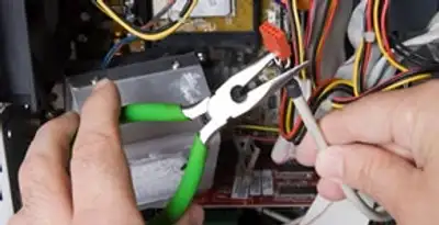 Licensed electrical contractor performing electrical repair with tools in Oldsmar, FL