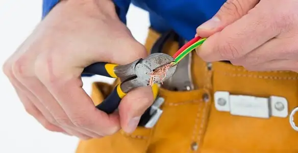 licensed electrician securing electrical wiring with professional tools during service work in Tampa, FL