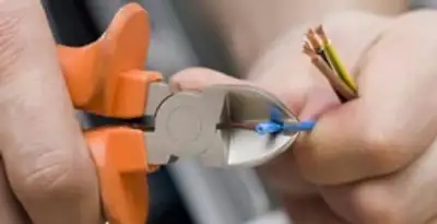 licensed electrician performing precise wire cutting and preparation during electrical service in Tampa, FL