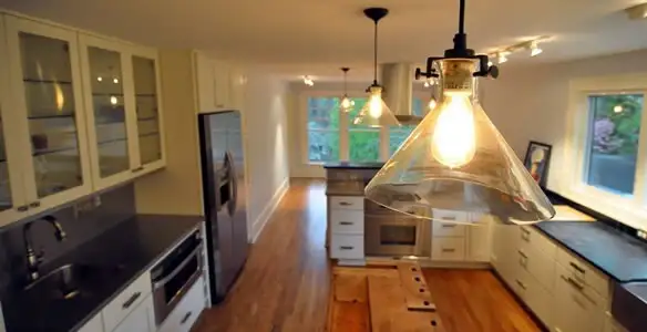 Residential electrician installing modern indoor light fixture in a home in Tampa, FL