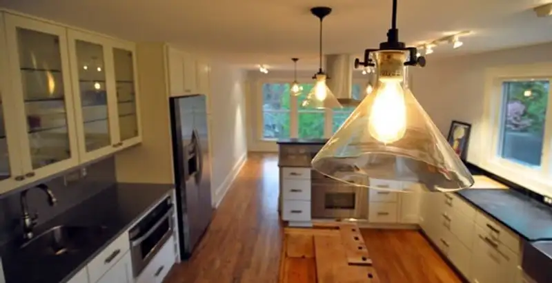Residential electrician installing modern indoor light fixture in a home in Tampa, FL